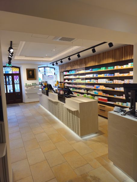 Moderne Verkaufsfläche mit Regalen, Kasse und hellem Bodenbelag.