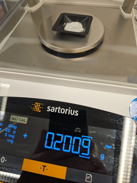 Waage zeigt 20,009 g auf einer Kunststoffschale.