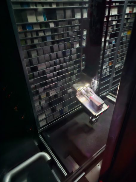 Ein Regal mit Schachteln und einem Greifer