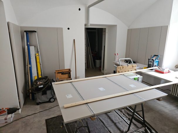 Ein leerer Raum mit Werkzeugen, einem Tisch und einer Leiter.