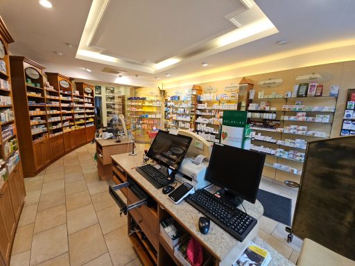 Apotheke mit Regalen voller Medikamente und einem Empfangstresen.