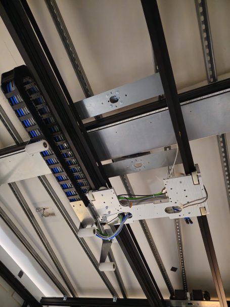 Anordnung von Metallteilen und Kabeln an einer Decke oder Wand.